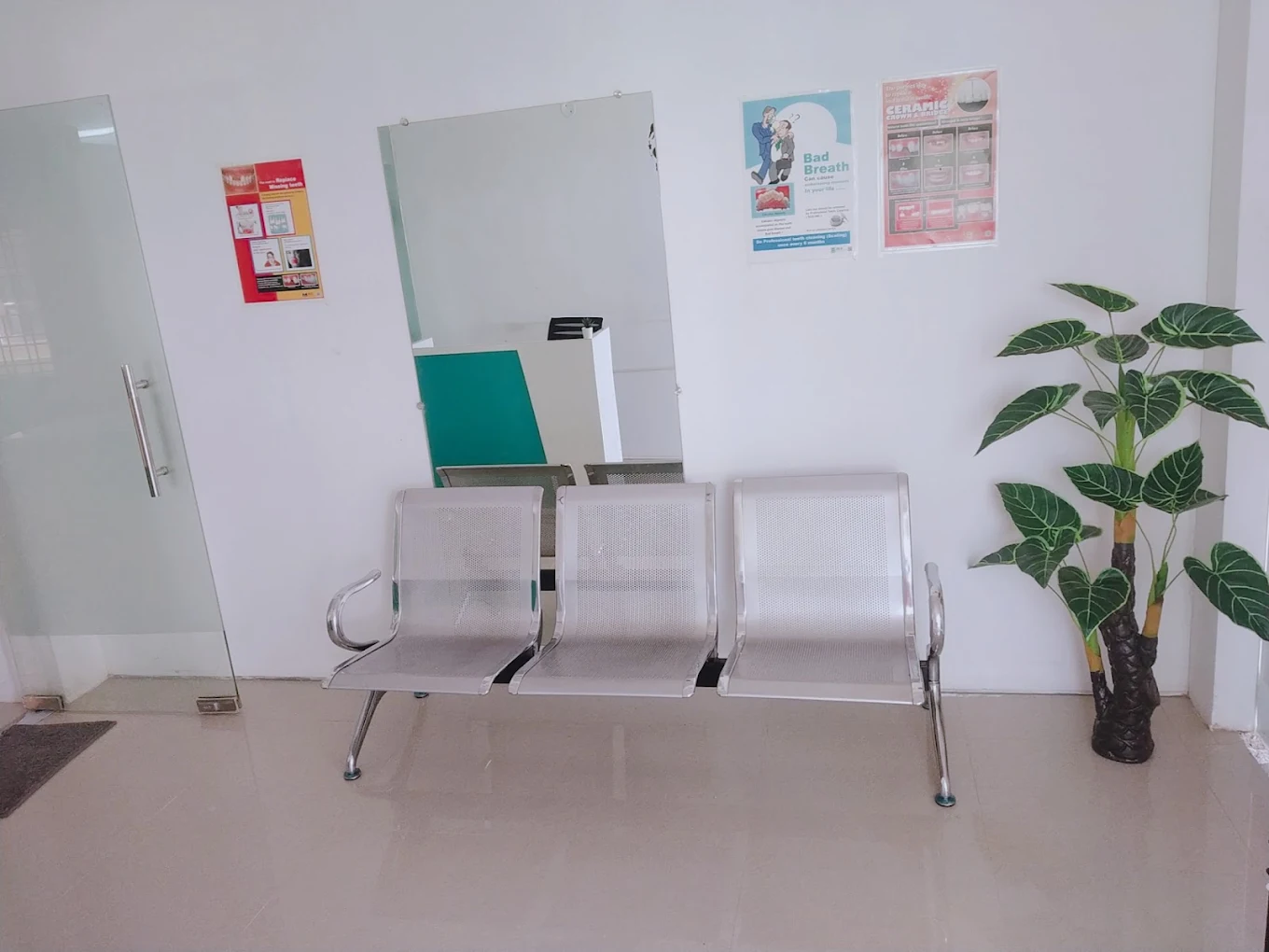 Waiting area with chairs and a plant at Smile Tree Dental Clinic.